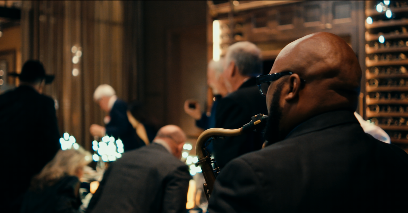 Live saxophonist performing among guests at an upscale indoor event