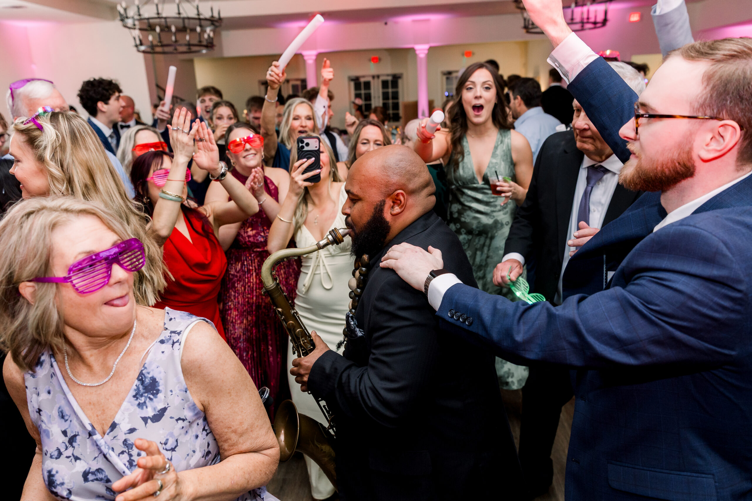 Interactive saxophonist performing with guests on a wedding reception dance floor